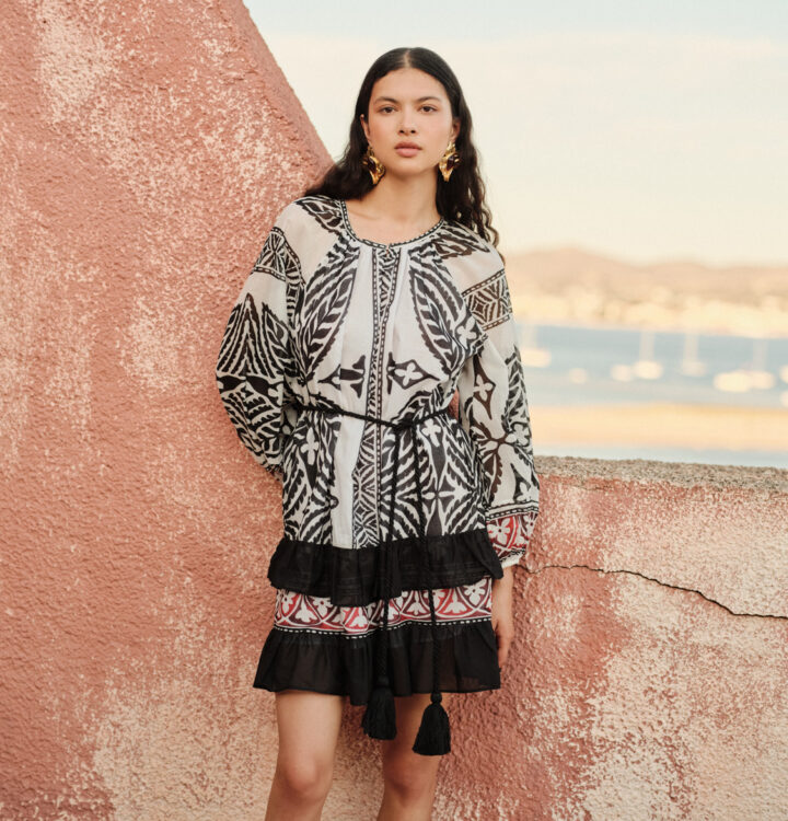 Model trägt schwarz gemustertes Kleid der Marke Devotion.