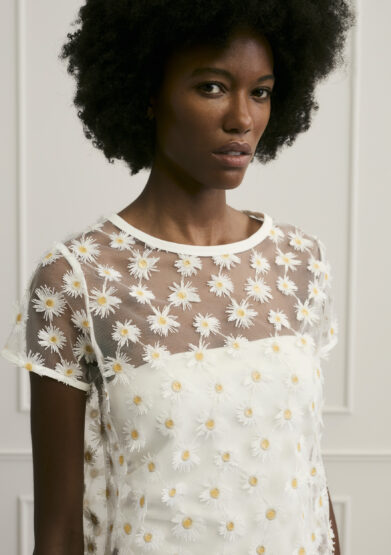 Model trägt Oberteil mit Gänseblümchen Ornamenten der Marke Luisa Cerano.