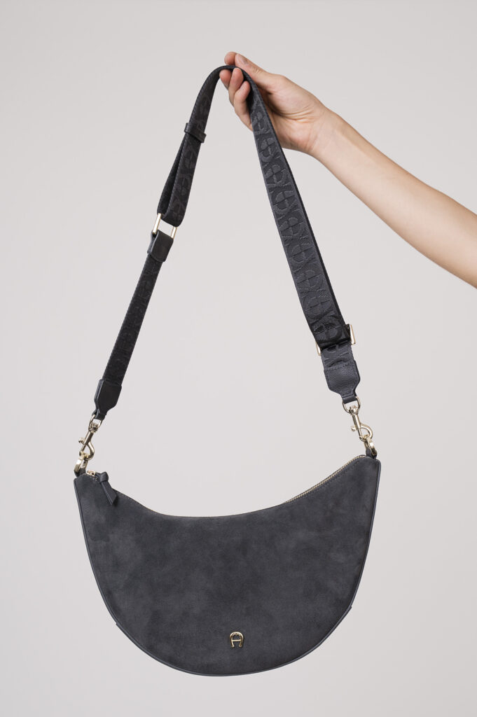 Model zeigt eine Tasche der Marke Aigner.