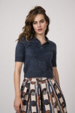 Model zeigt einen taubenblauen Kurzarmpullover mit Kragen der Marke Lisa Yang.