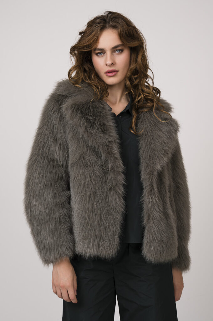 Model zeigt eine Blazerjacke in smaragd-grün der Marke Susanne Bommer und eine hellgraue Fake Fur Jacke Betta Corradi.