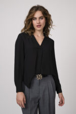 Model zeigt eine schwarze Bluse mit Strass-Dekor am Kragen der Marke Janice & Jo, eine mittelgraue Stoffhose der Marke Cambio und einen Gürtel der Marke Dorothee Schumacher.