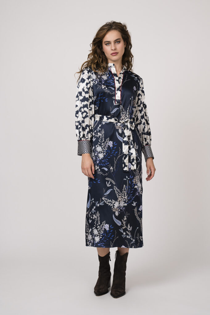 Model zeigt ein langes, blau-gemustertes Kleid der Marke Herzens’Angelegenheit.