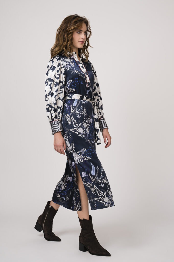 Model zeigt ein langes, blau-gemustertes Kleid der Marke Herzens’Angelegenheit.