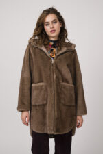 Model zeigt eine bunt gemusterte Bluse der Marke unbreak.it, eine bordeaux-farbige Kordhose der Marke Cambio, einen Gürtel der Marke Aigner und ein Fake Fur Mantel in taupe der Marke Betta Corradi.