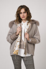 Model zeigt eine weiße Bluse mit Schleife der Marke Luisa Cerano, ein Kurzarmpullover in taupe der Marke Absolut Cashmere, eine karierte Stoffhose der Marke Cambio und eine Jacke der Marke Marco del Forte.