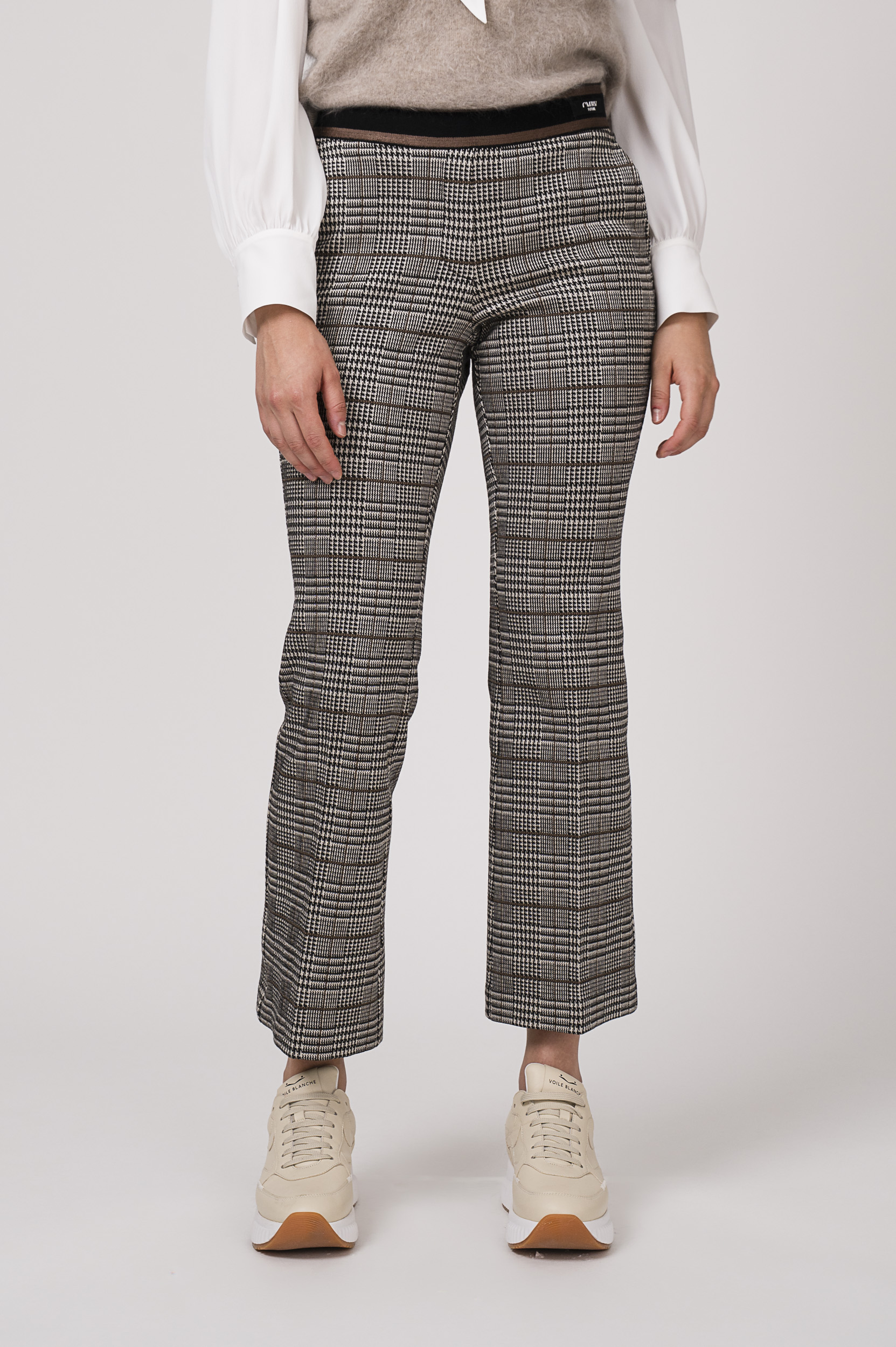 Model zeigt karierte Hose der Marke Cambio und Sneaker der Marke Voile Blanche.