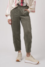 Model zeigt olivgrüne Hose der Marke Cambio und Sneaker der Marke Voile Blanche.