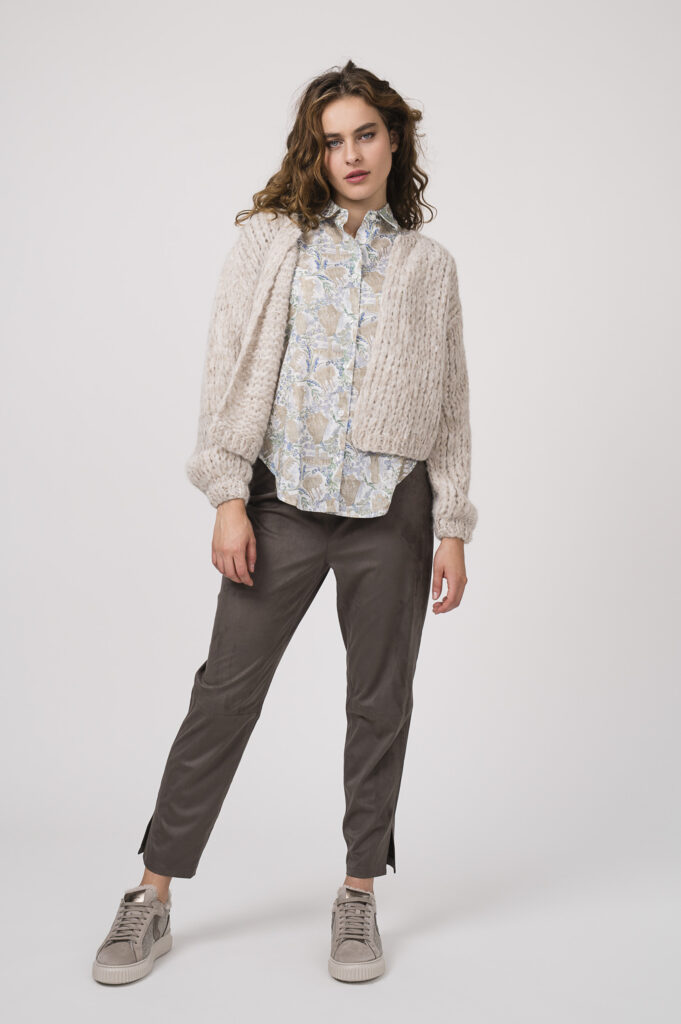 Model zeigt eine sand-farbige Strickweste der Marke Michele & Hoven, seine gemusterte Bluse der Marke Rossana Diva, eine braune Hose der Marke FFC und Sneaker der Marke Voile Blanche.