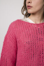 Model zeigt einen pinken Strickpullover der Marke Michele & Hoven, eine beige gemusterte Bluse der Marke Grace.