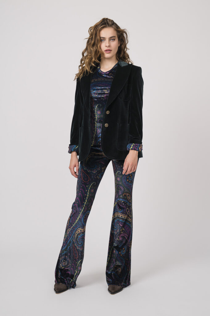 Model zeigt ein samtiges Outfit der Marke ETRO, bestehend aus einer petrol-farbig gemusterten Hose und einem Shirt sowie einem smaragd-grünen Blazer.