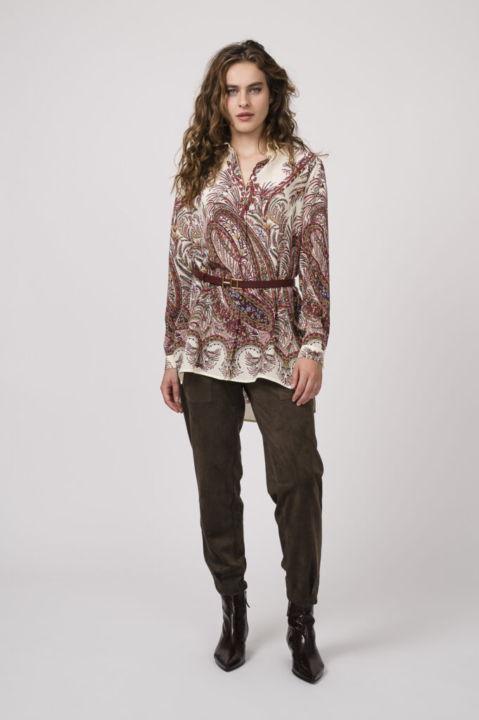 Model zeigt eine beige, bordeaux-farbige Bluse der Marke ETRO, einen Gürtel der Marke Hemisphere und eine schoko-braune Hose der Marke Cambio.