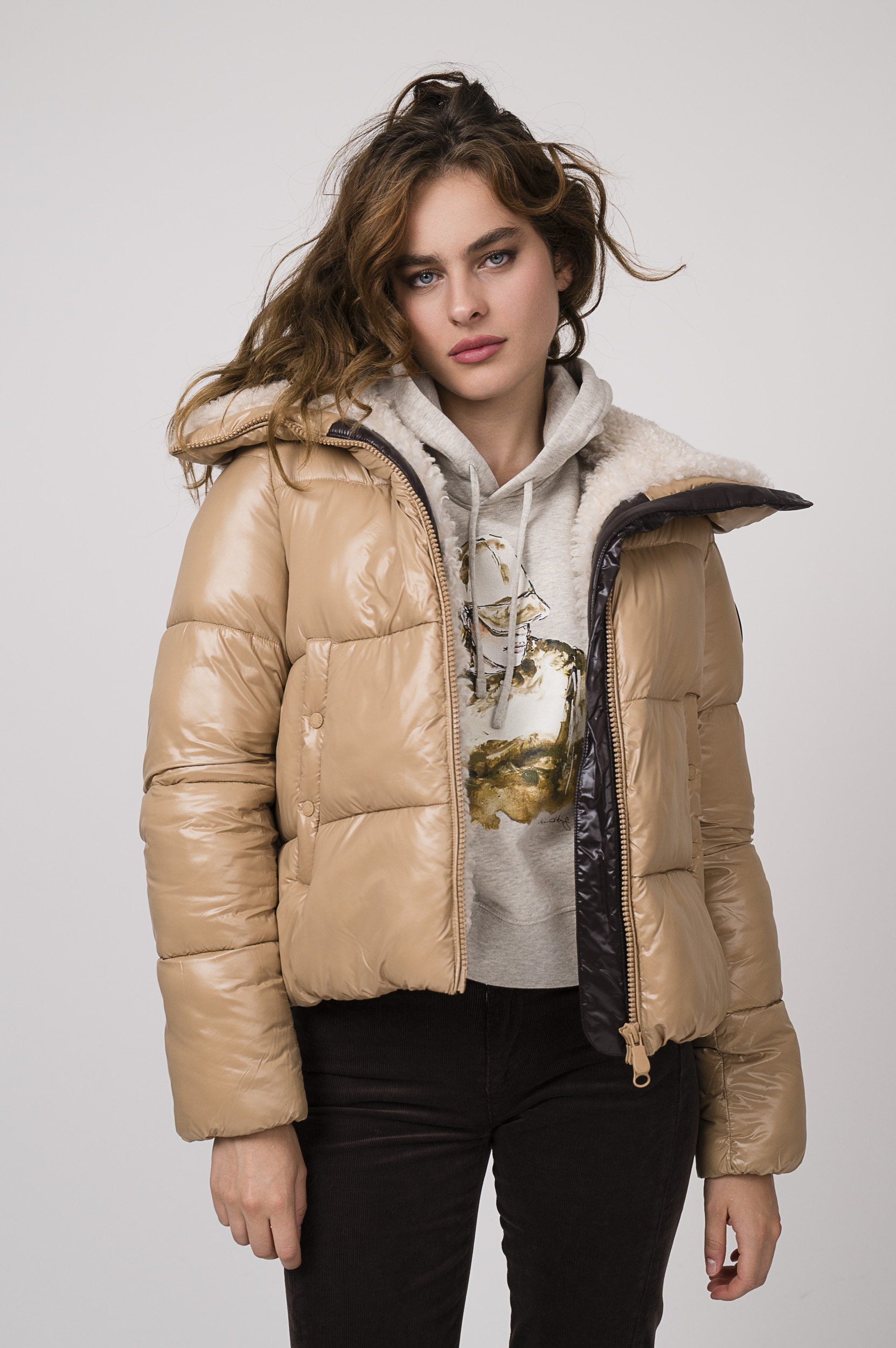 Model zeigt eine Steppjacke der Marke Save the Duck, einen Lounge Sweater der Marke unartig und eine schoko-braune Kordhose der Marke 7 for all mankind.
