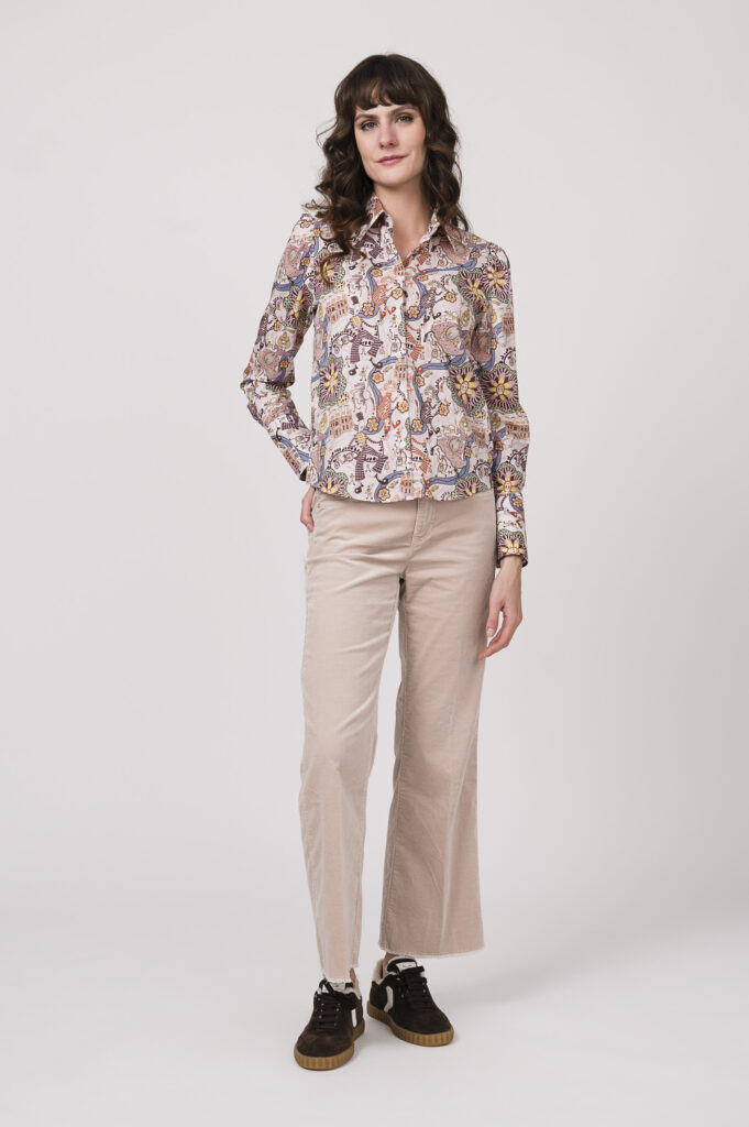 Model zeigt eine Langarmbluse der Marke Robert Friedman in rosa mit Muster, eine Cordhose der Marke Cambio in natur, dazu Sneaker der Marke Voile Blanche in braun