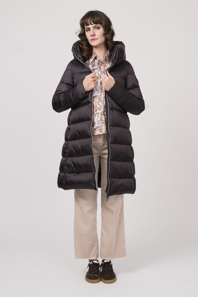 Model zeigt einen Steppmantel der Marke Save der Duck, dazu eine Langarmbluse der Marke Robert Friedman in rosa mit Muster, eine Cordhose der Marke Cambio in natur, dazu Sneaker der Marke Voile Blanche in braun