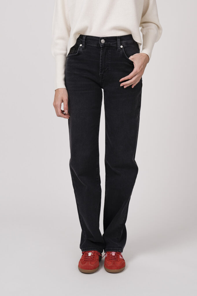 Model zeigt einen Pullover der Marke FFC in winterweiß, dazu eine Jeans der Marke 7 for all mankind und Sneaker der Marke Caval in rot