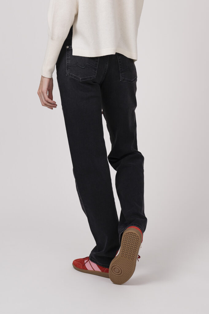 Model zeigt einen Pullover der Marke FFC in winterweiß, dazu eine Jeans der Marke 7 for all mankind und Sneaker der Marke Caval in rot