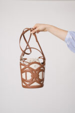 Model zeigt eine braun-beige Tasche der Marke Aigner.