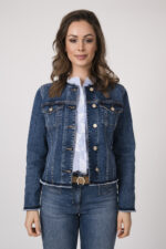 Model trägt eine blaue Jeansjacke der Marke 7 for all mankind, eine hellblau-weiß gemusterte Bluse der Marke 0039 Italy, eine blaue Jeans der Marke Luisa Cerano und einen beigen Gürtel der Marke Aigner.
