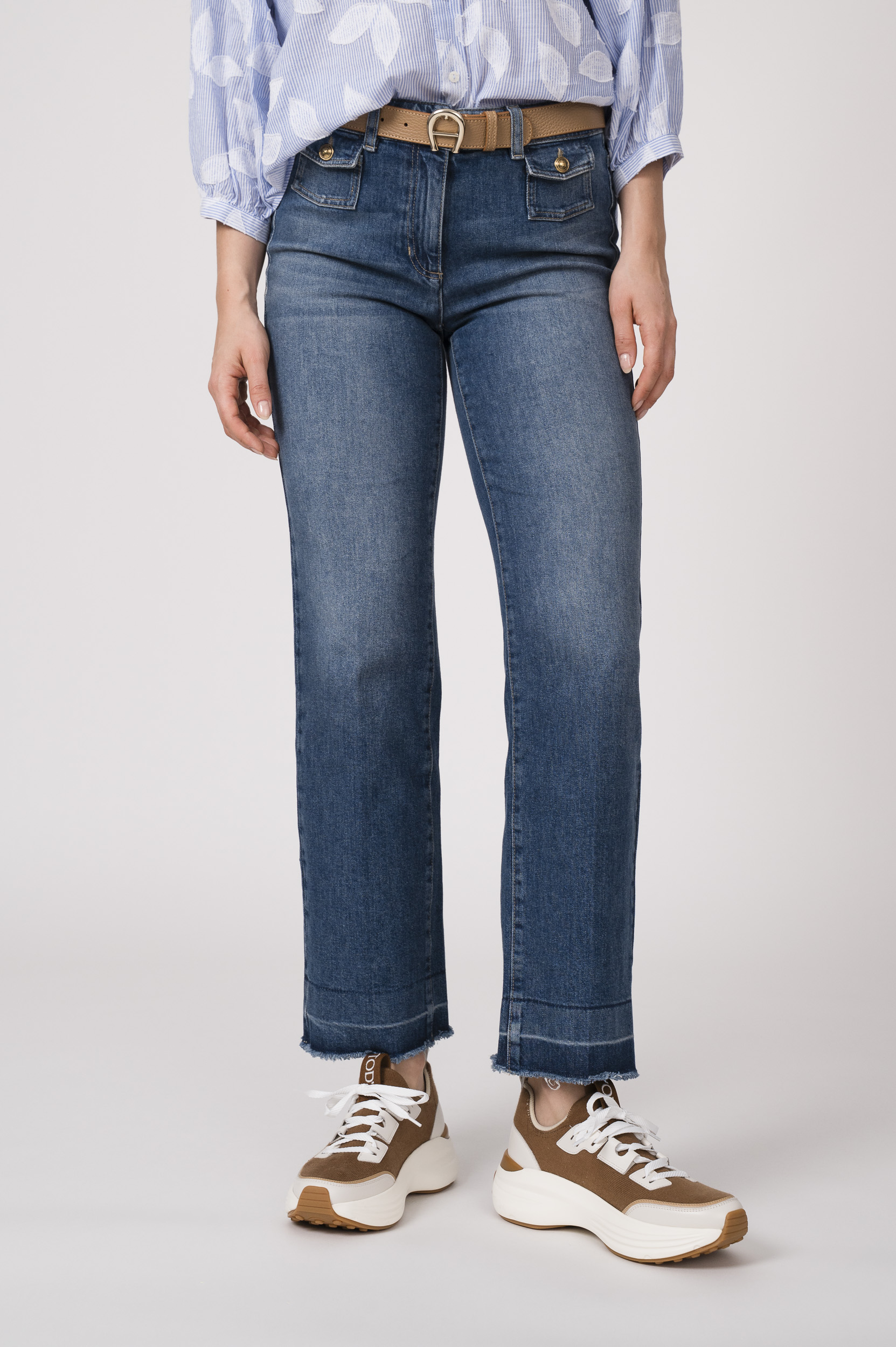Model trägt eine blaue Jeans der Marke Luisa Cerano und einen beigen Gürtel der Marke Aigner.