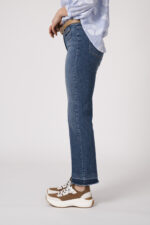 Model trägt eine blaue Jeans der Marke Luisa Cerano und einen beigen Gürtel der Marke Aigner.