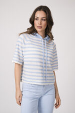 Model trägt einen hellblau-weiß gestreiften Pullover der Marke Allude und eine hellblaue Hose der Marke Cambio.