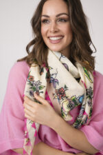 Model trägt einen feinen Cashmere-Kurzarmpullover der Marke Absolut Cashmere in Rosa, dazu einen passenden Schal der Marke Faliero Sarti.