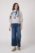 Model trägt einen feinen Cashmere-Kurzarmpullover der Marke Absolut Cashmere in Blau, dazu einen passenden Schal der Marke Faliero Sarti, Sneaker der Marke Caval.