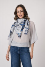 Model trägt einen feinen Cashmere-Kurzarmpullover der Marke Absolut Cashmere in Blau, dazu einen passenden Schal der Marke Faliero Sarti.