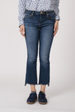 Model trägt eine Bluse mit Blumenmuster der Marke Rossana Diva, eine Jeans der Marke True Religion und blaue Sneaker der Marke Caval