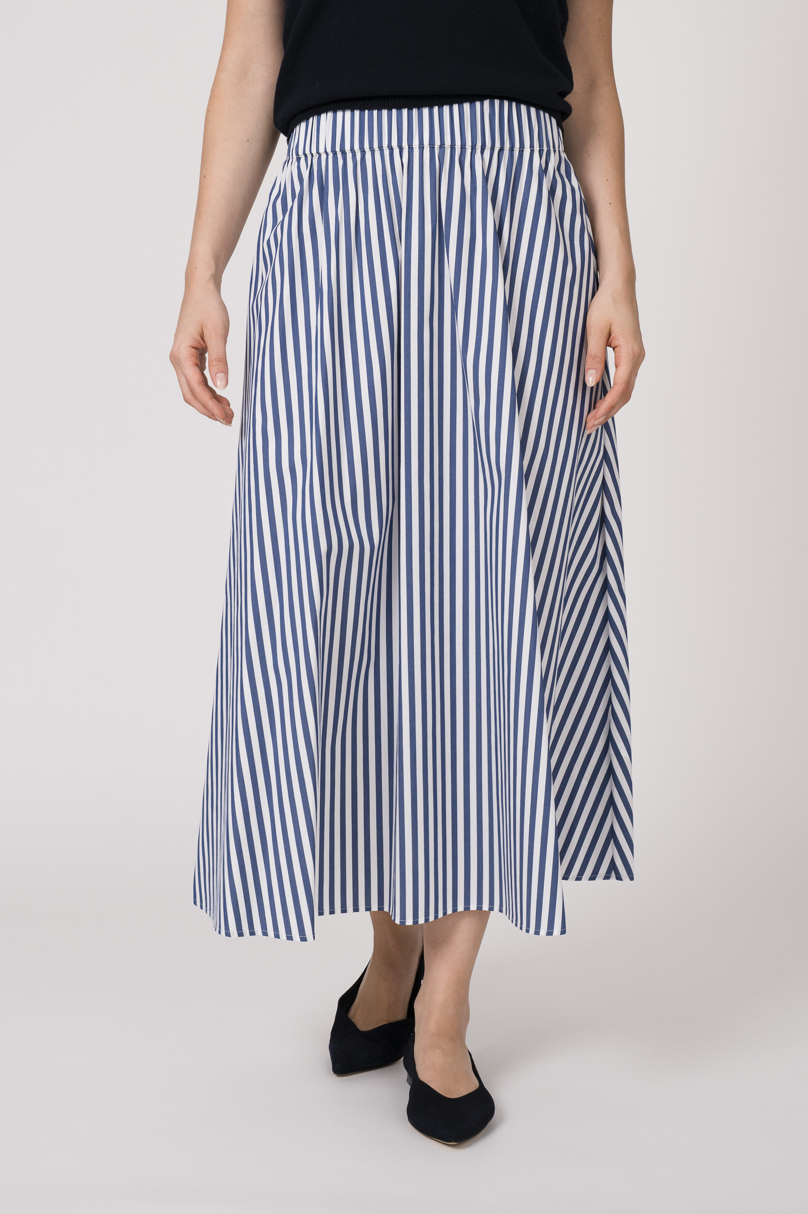 Model trägt einen blau weiß gestreiften Rock der Marke JOOP.