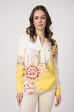 Model trägt eine beige-gelbe Bluse der Marke Herzens und eine sand-farbige Stoffhose der Marke Mason’s.