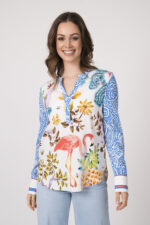 Model trägt eine bunte Bluse der Marke Herzens und eine hellblaue Jeans der Marke Closed.