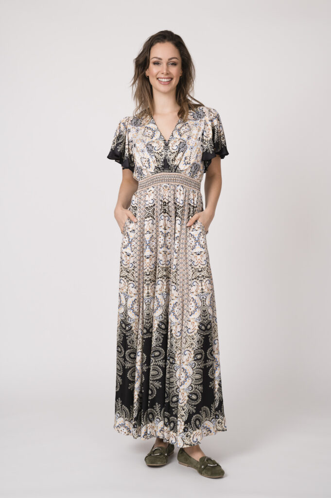 Model trägt ein fließendes gemustertes Kleid und schwarz und beige der Marke Hale Bob.