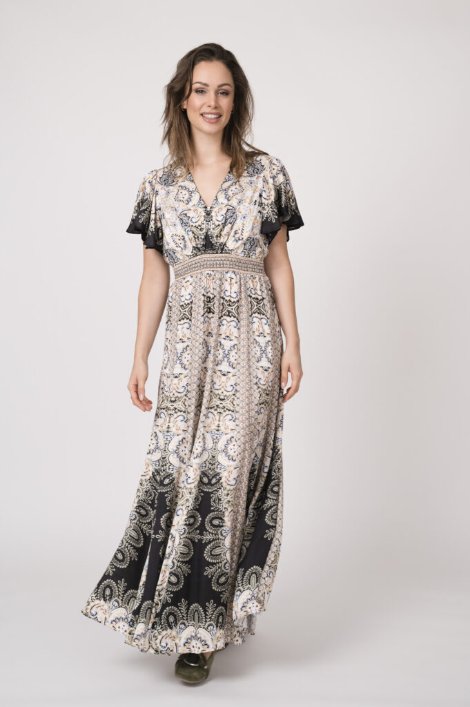 Model trägt ein fließendes gemustertes Kleid und schwarz und beige der Marke Hale Bob.