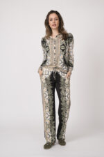 Model trägt eine fließend gemusterte Bluse und Hose in schwarz und beige der Marke Hale Bob.