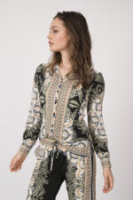 Model trägt eine fließend gemusterte Bluse und Hose in schwarz und beige der Marke Hale Bob.