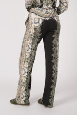 Model trägt eine fließend gemusterte Hose in schwarz und beige der Marke Hale Bob.