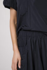 Model trägt eine Bluse und einen dazu passenden Rock der Marke Susanne Bommer in dunkelblau.