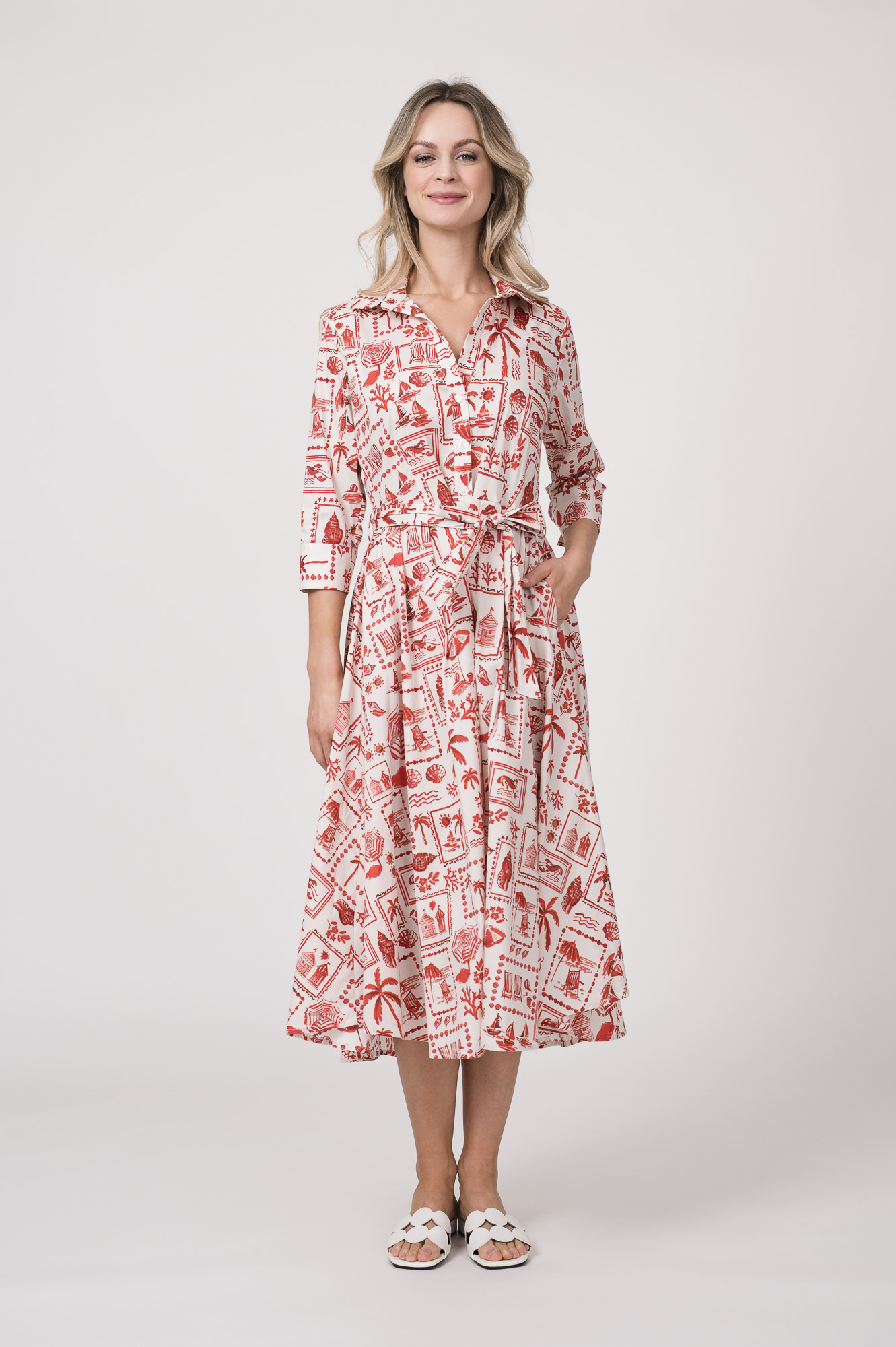 Model trägt ein langes Kleid der Marke Rossana Diva, mit rotem Muster.