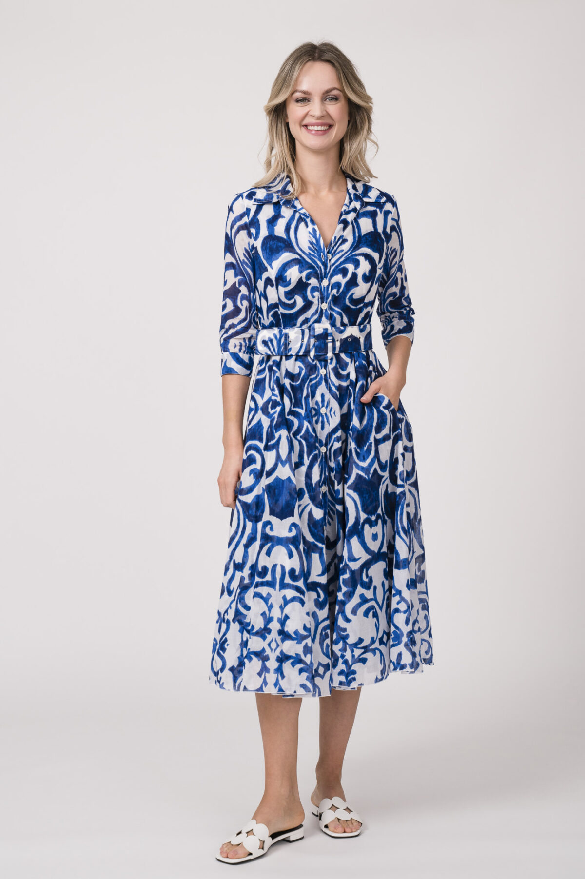 Model trägt ein langes Kleid der Marke Samantha Sung mit blauem Muster.