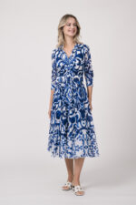 Model trägt ein langes Kleid der Marke Samantha Sung mit blauem Muster.