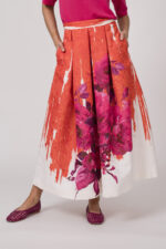 Model trägt einen orange-pink-weißen Rock von Lunatica.