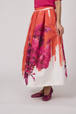 Model trägt einen orange-pink-weißen Rock von Lunatica.