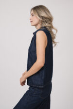 Model trägt eine dunkelblaue ärmellose Jeansbluse der Marke 7 for all mankind.