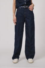 Model trägt eine dunkelblaue Jeanshose der Marke 7 for all mankind und einen dunkelblauen Gürtel von Aigner.