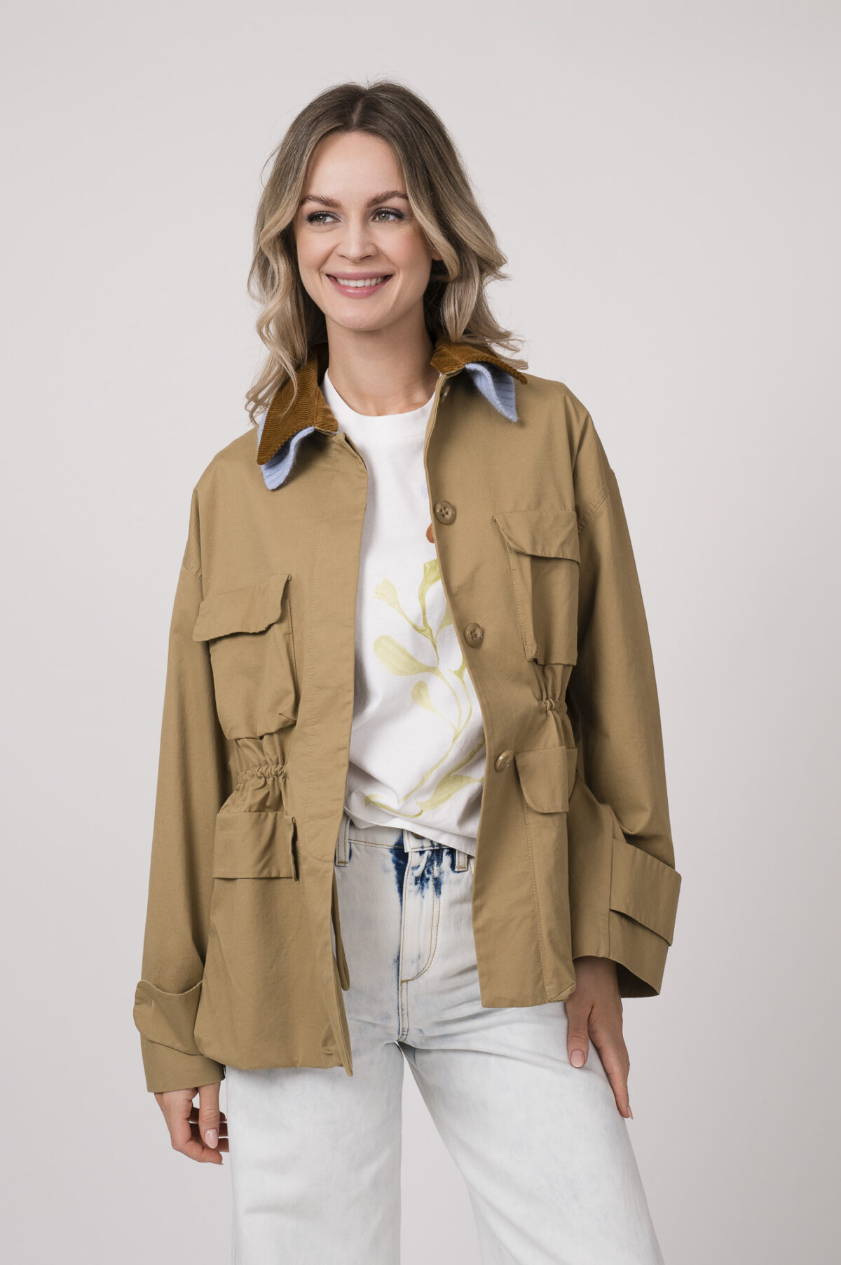 Model trägt eine beige Jacke der Marke Dorothee Schumacher mit hellblauem Strickkragen, ein helles Shirt der Marke Dorothee Schumacher.
