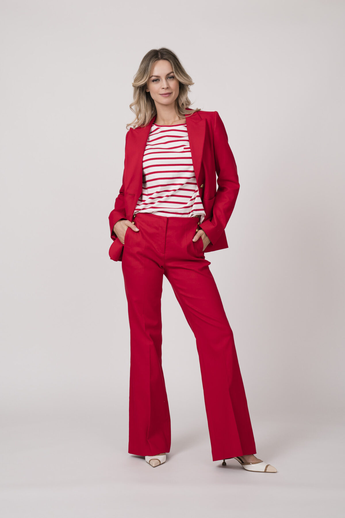 Model trägt einen roten Blazer, eine rote Hose und ein weiß-rot gestreiftes Shirt von Luisa Cerano.