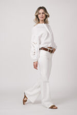 Model trägt eine weiße Bluse der Marke Dorothee Schumacher und eine weiße Jeans von True Religion. Der braue Gürtel ist von Dorothee Schumacher.