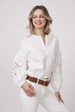 Model trägt eine weiße Bluse der Marke Dorothee Schumacher. Der braue Gürtel ist von Dorothee Schumacher.